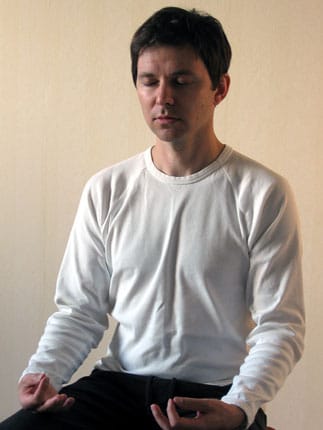 Reikioppilas harjoittaa reikin meditaatiota istuen